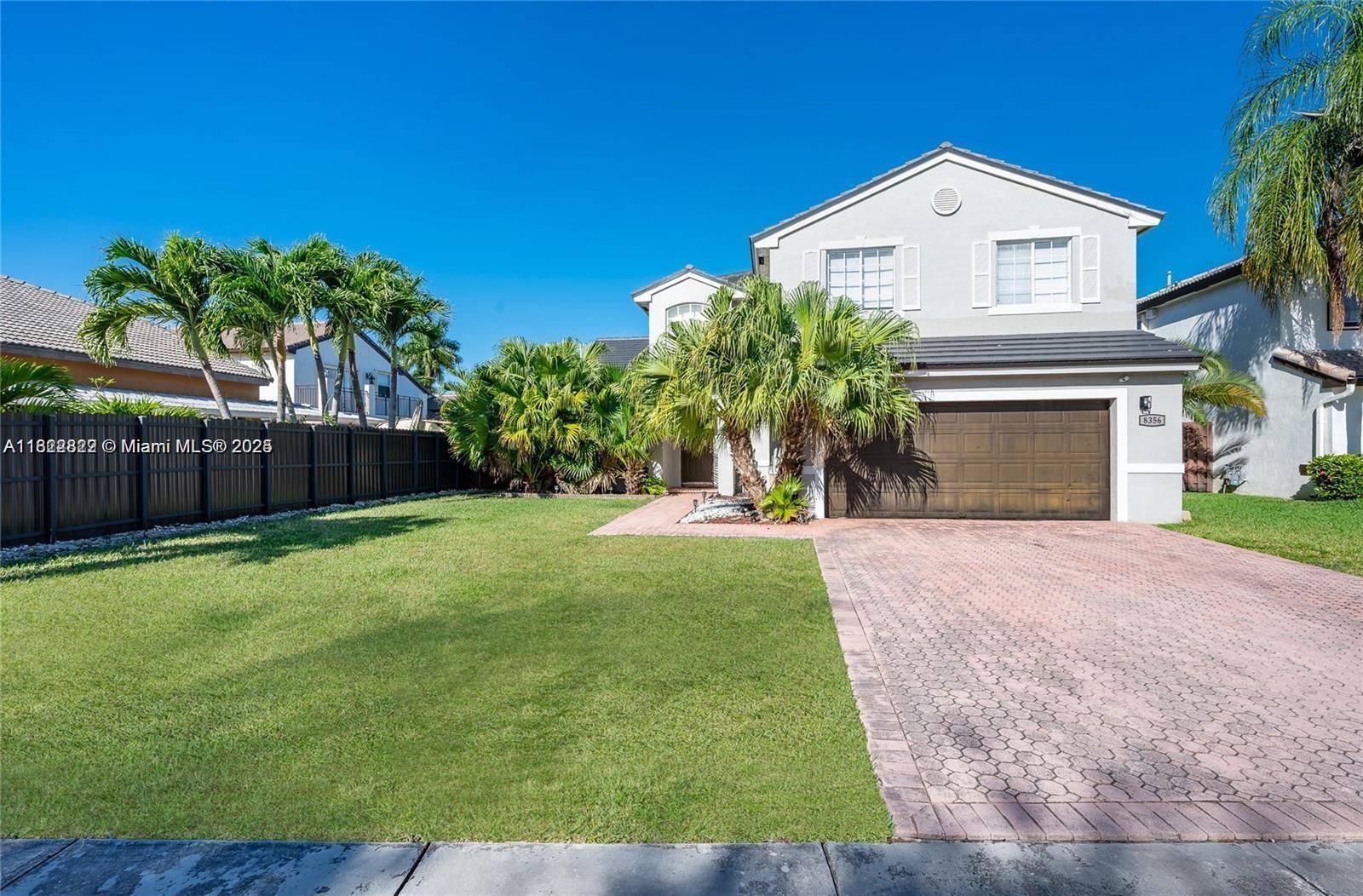 8356 Southwest 158th Avenue Miami, FL 33193 - Photo 2 of 48 a front view of a house with a yard and garage