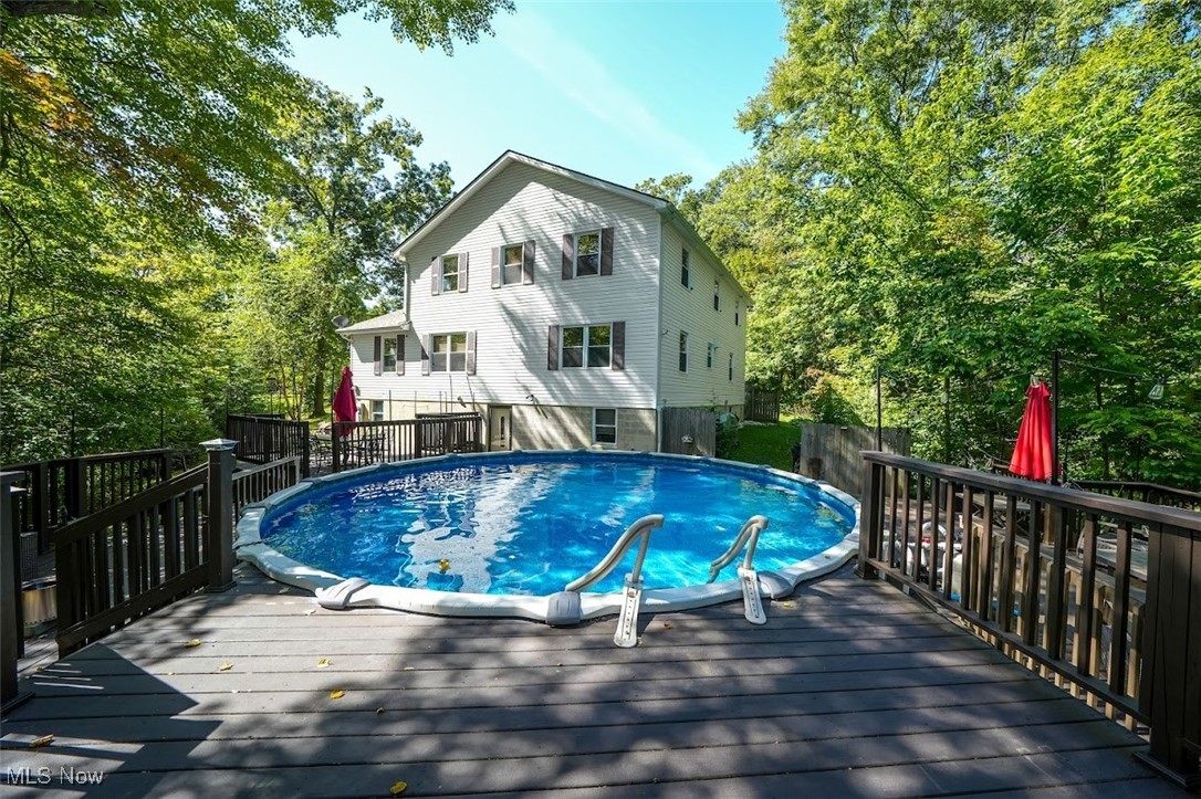 17808 Nash Road Middlefield, OH 44062 - Photo 9 of 43 View of swimming pool featuring a wooden deck, view of scattered trees, and a fenced backyard
