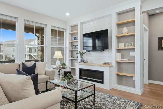 1925 Canyonpoint Place Castle Pines, CO 80108 - Photo 11 of 50 a living room with furniture a flat screen tv and a fireplace