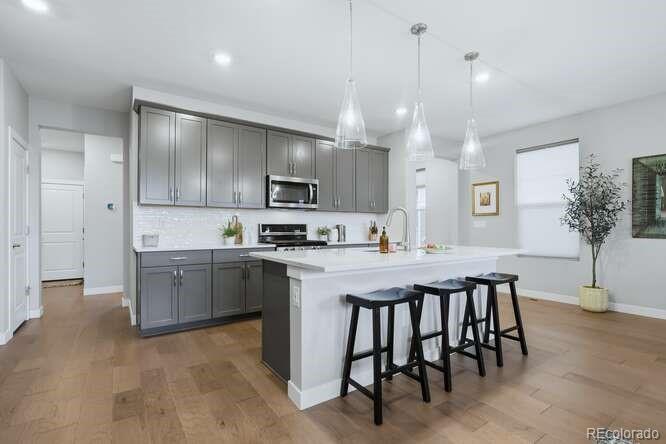 1925 Canyonpoint Place Castle Pines, CO 80108 - Photo 18 of 50 a kitchen with kitchen island granite countertop a sink a center island and appliances