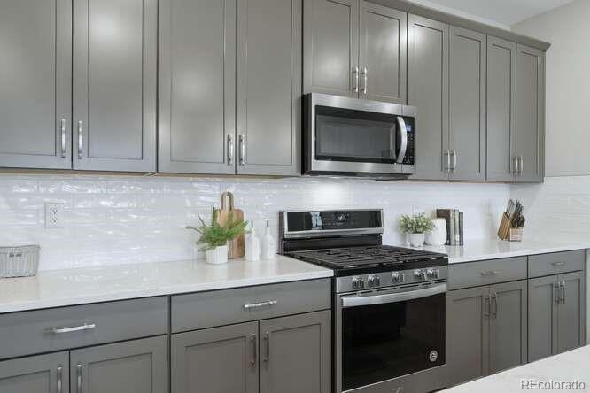 1925 Canyonpoint Place Castle Pines, CO 80108 - Photo 19 of 50 a kitchen with stainless steel appliances wooden cabinets and a stove top oven