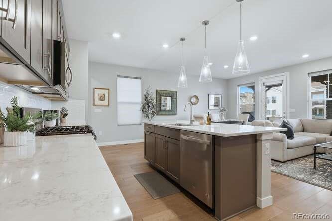 1925 Canyonpoint Place Castle Pines, CO 80108 - Photo 20 of 50 a large kitchen with kitchen island a large counter top space a sink stainless steel appliances and cabinets