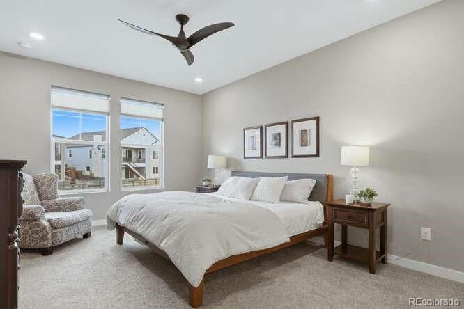 1925 Canyonpoint Place Castle Pines, CO 80108 - Photo 23 of 50 a bedroom with a large bed and a chandelier