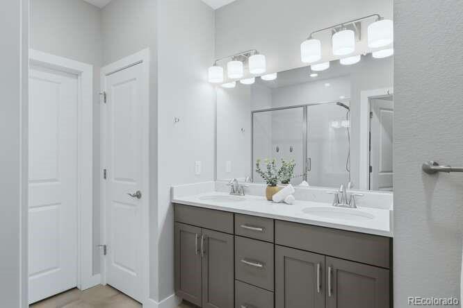 1925 Canyonpoint Place Castle Pines, CO 80108 - Photo 25 of 50 a bathroom with a double vanity sink and a mirror