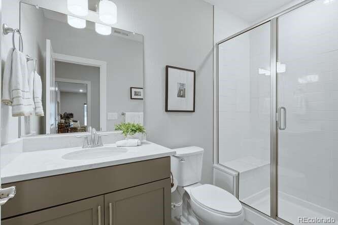 1925 Canyonpoint Place Castle Pines, CO 80108 - Photo 34 of 50 a bathroom with a sink a toilet a mirror and shower