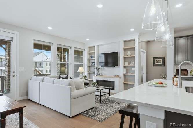 1925 Canyonpoint Place Castle Pines, CO 80108 - Photo 6 of 50 a living room with fireplace furniture and a flat screen tv