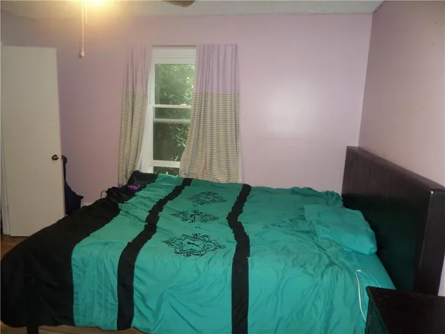 a bed sitting in a bedroom next to a window