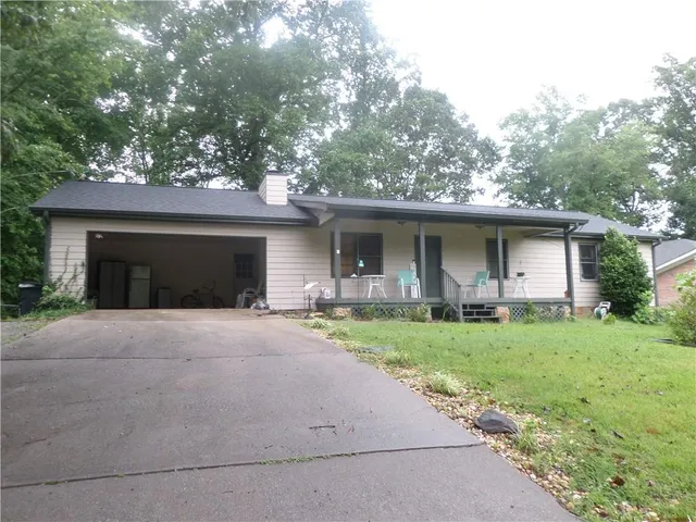 front view of a house with a yard and potted plants