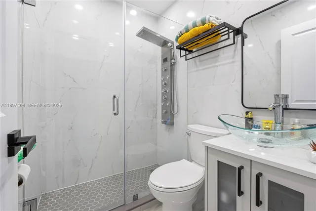 a bathroom with a granite countertop sink toilet and shower