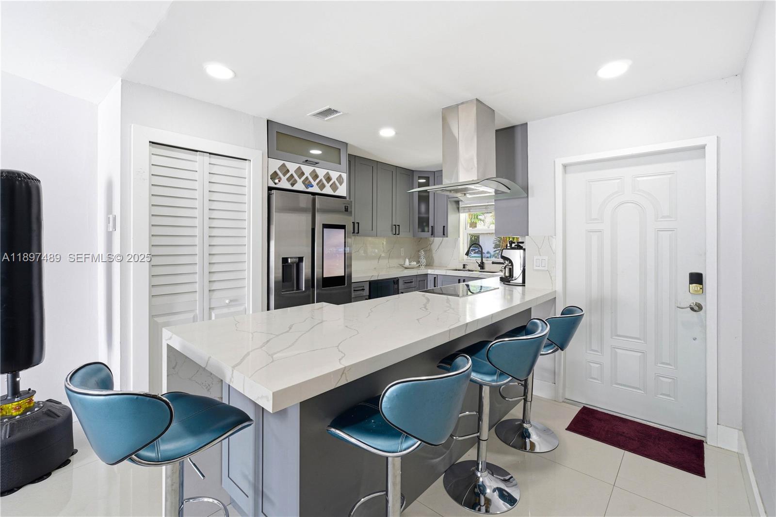 13765 Southwest 54th Lane Miami, FL 33175 - Photo 5 of 30 a kitchen with kitchen island a dining table chairs cabinets and stainless steel appliances