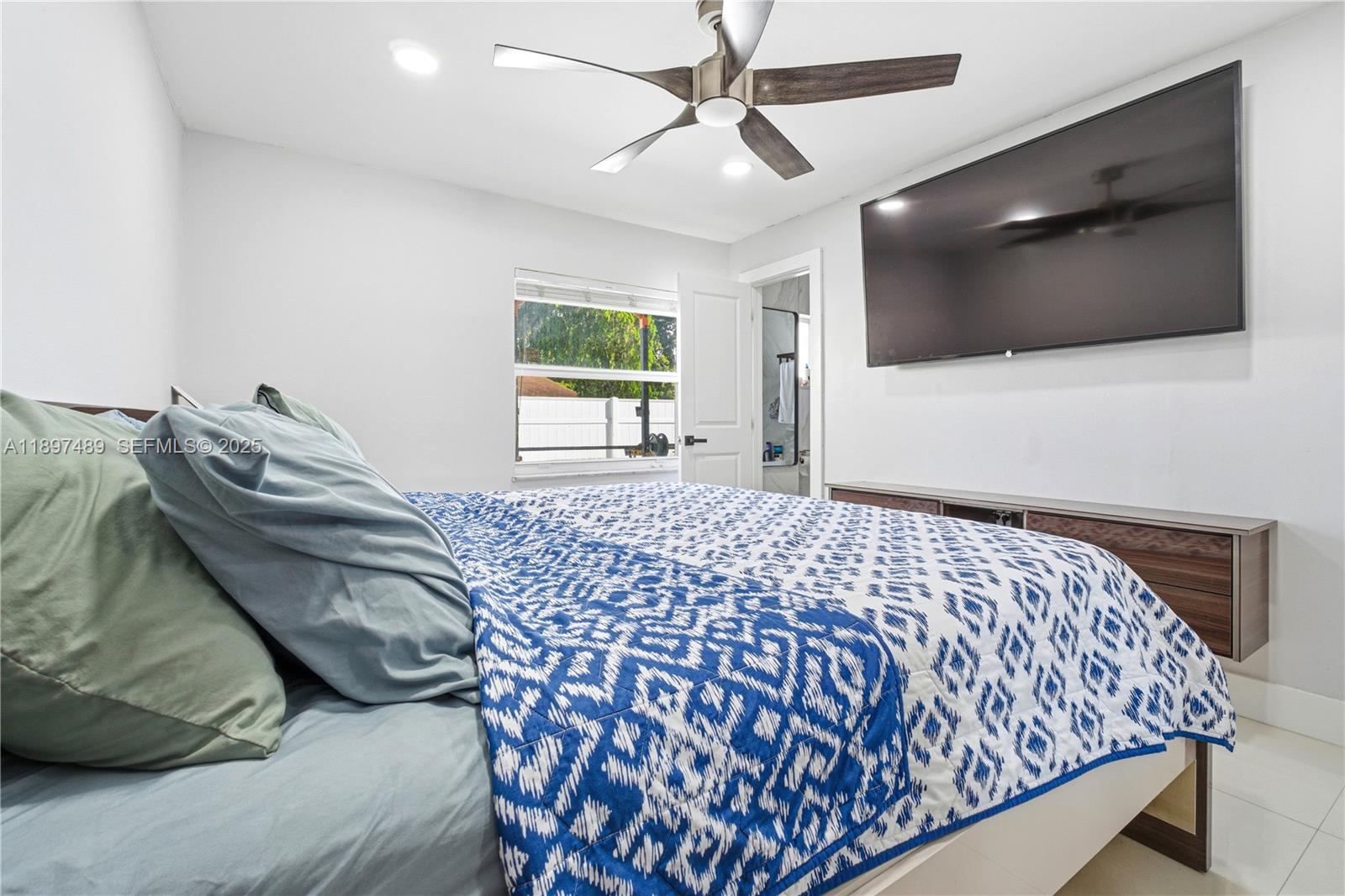 13765 Southwest 54th Lane Miami, FL 33175 - Photo 9 of 30 a bedroom with a bed and flat screen tv