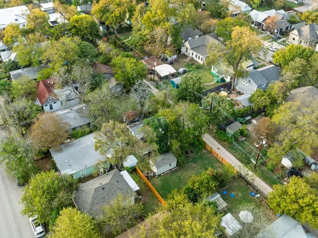 an aerial view of residential houses with outdoor space and trees