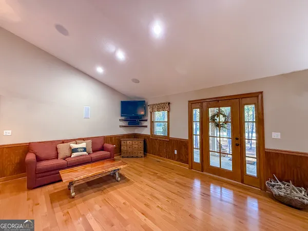 a living room with a couch and a dining table with wooden floor