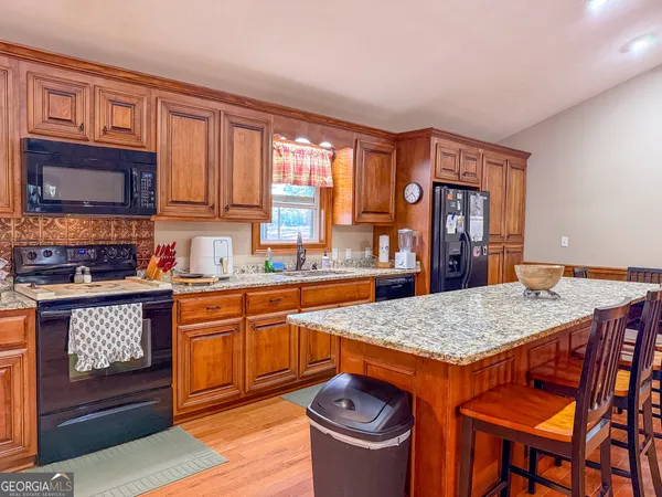 a kitchen with stainless steel appliances granite countertop a stove a sink dishwasher and cabinets with wooden floor