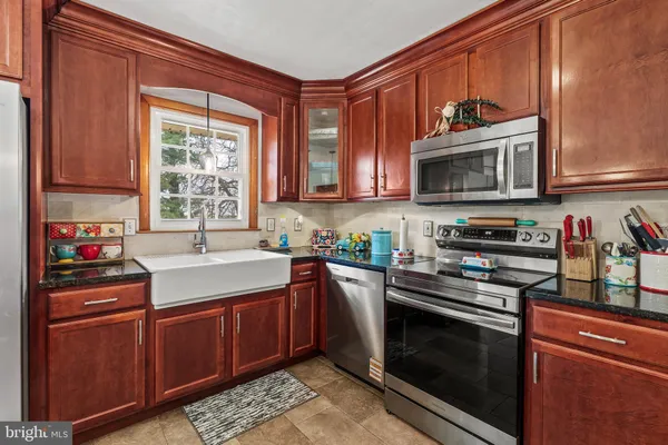 a kitchen with stainless steel appliances granite countertop a stove microwave and sink