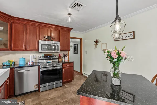 a kitchen with stainless steel appliances granite countertop a refrigerator a stove a sink dishwasher with a dining table and chair