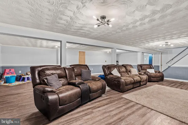 a media room with lots of chairs and wooden floor
