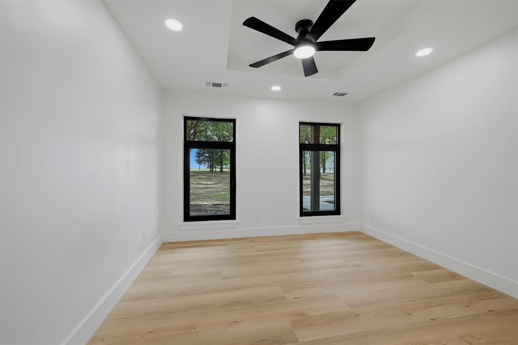 410 Arkansas Road Sadler, TX 76264 - Photo 23 of 40 Room featuring light wood-finish flooring, white walls, and a tray ceiling with recessed lighting