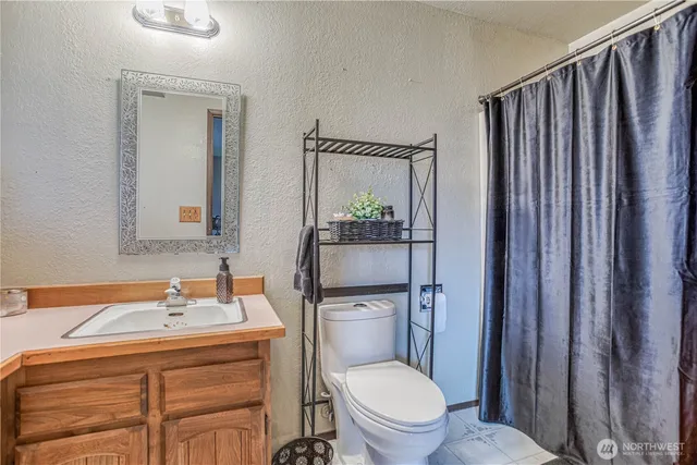 a bathroom with a granite countertop toilet sink and mirror