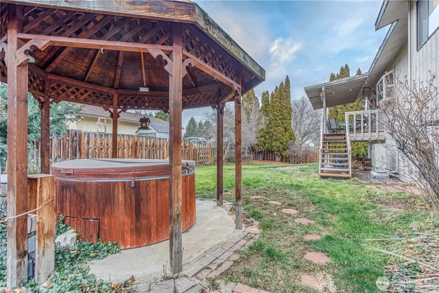 a view of a backyard with table and chairs under an umbrella