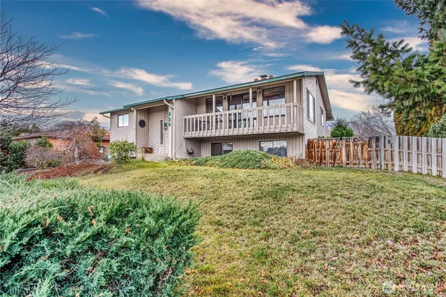 a view of an house with backyard space and balcony
