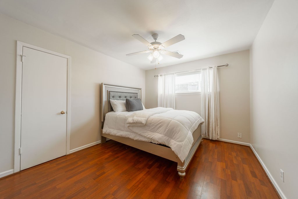 4723 Merwin Street Houston, TX 77027 - Photo 11 of 29 a bedroom with a bed and wooden floor