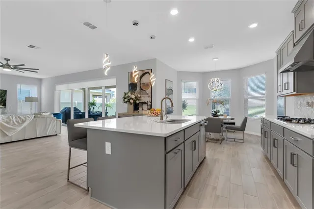 a kitchen with counter top space sink stove and wooden floor