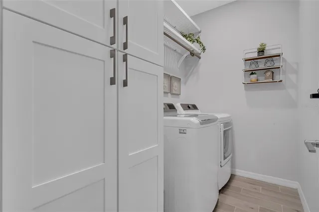 a utility room with cabinets washer and dryer