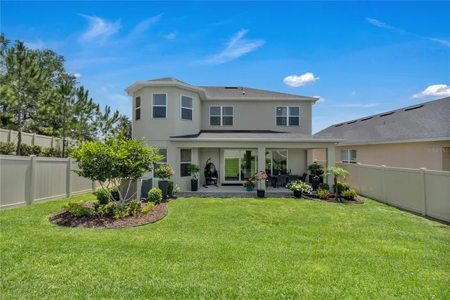 a view of a chair and table in backyard of the house