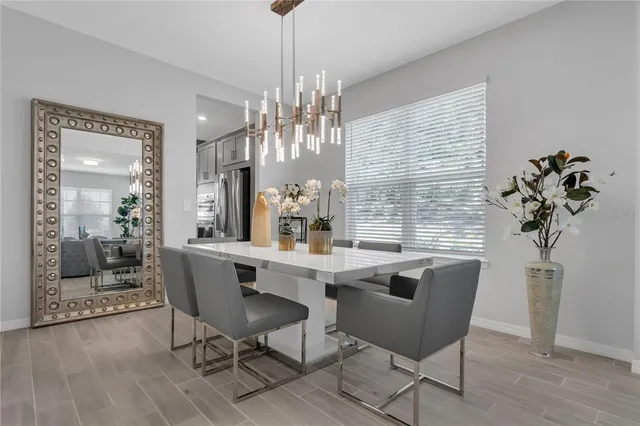 a dining room with furniture a chandelier and wooden floor
