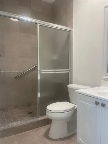 a white toilet sitting next to a shower