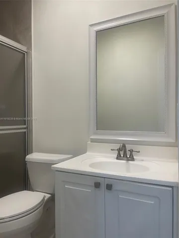 a bathroom with a sink toilet and a mirror