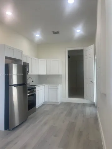 a kitchen with a refrigerator and a stove top oven