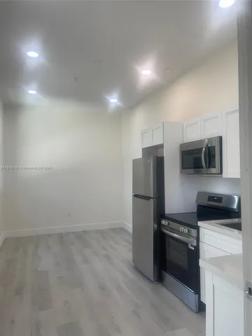 a kitchen with stainless steel appliances a refrigerator and a stove top oven