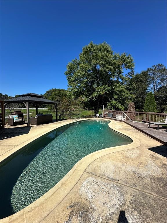 3400 North Sharon Church Road Loganville, GA 30052 - Photo 19 of 53 a view of a swimming pool and a yard