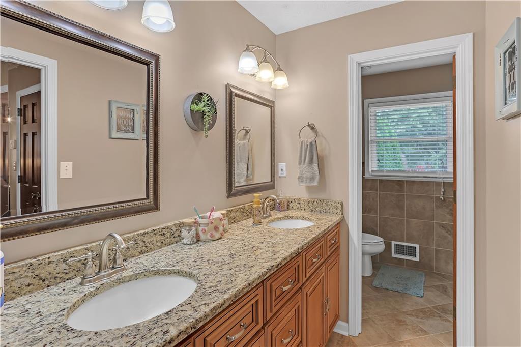 3400 North Sharon Church Road Loganville, GA 30052 - Photo 35 of 53 a bathroom with a granite countertop double vanity sink and a mirror