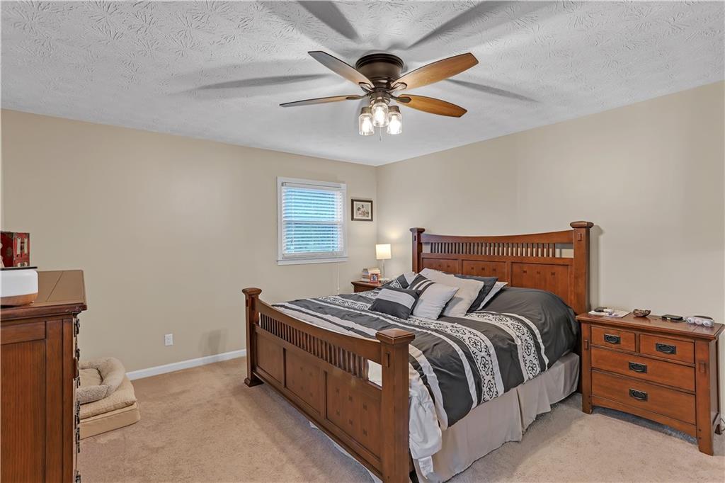 3400 North Sharon Church Road Loganville, GA 30052 - Photo 36 of 53 a bedroom with a bed and a chandelier