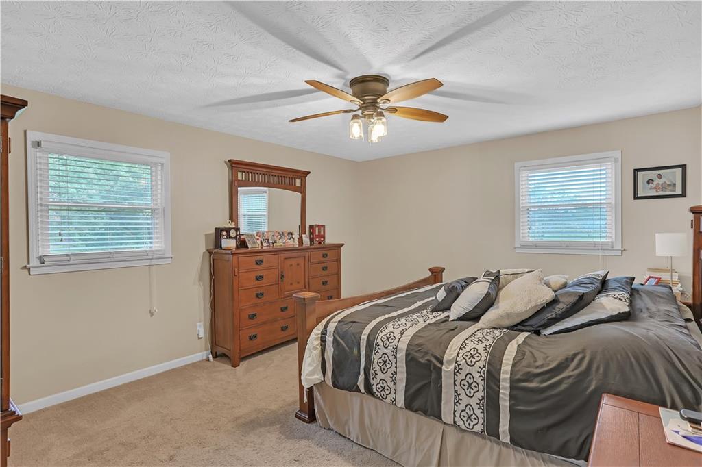 3400 North Sharon Church Road Loganville, GA 30052 - Photo 37 of 53 a bedroom with a bed and a chandelier