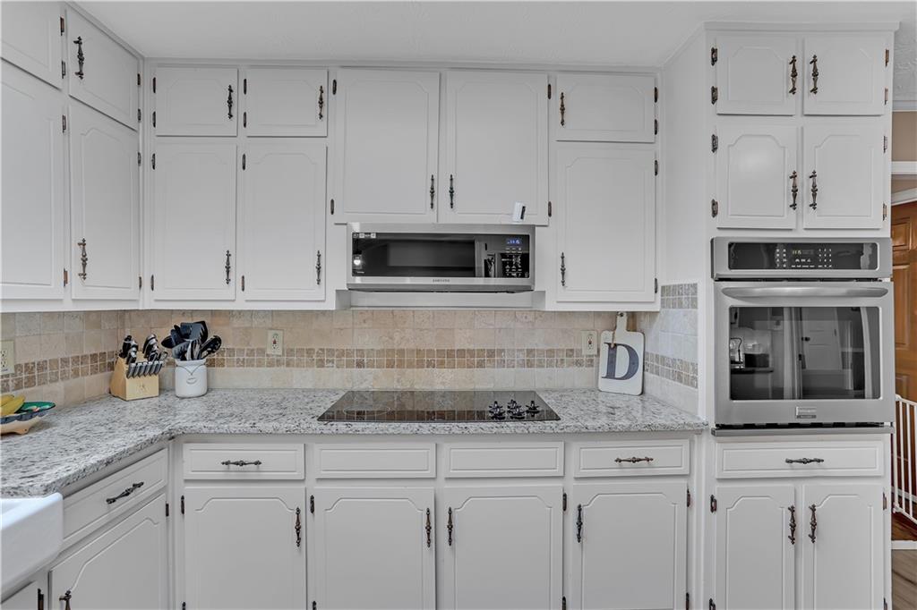 3400 North Sharon Church Road Loganville, GA 30052 - Photo 44 of 53 a kitchen with granite countertop white cabinets and white stainless steel appliances
