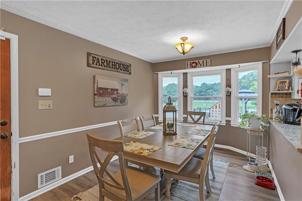 3400 North Sharon Church Road Loganville, GA 30052 - Photo 47 of 53 a dining room with furniture a chandelier and wooden floor