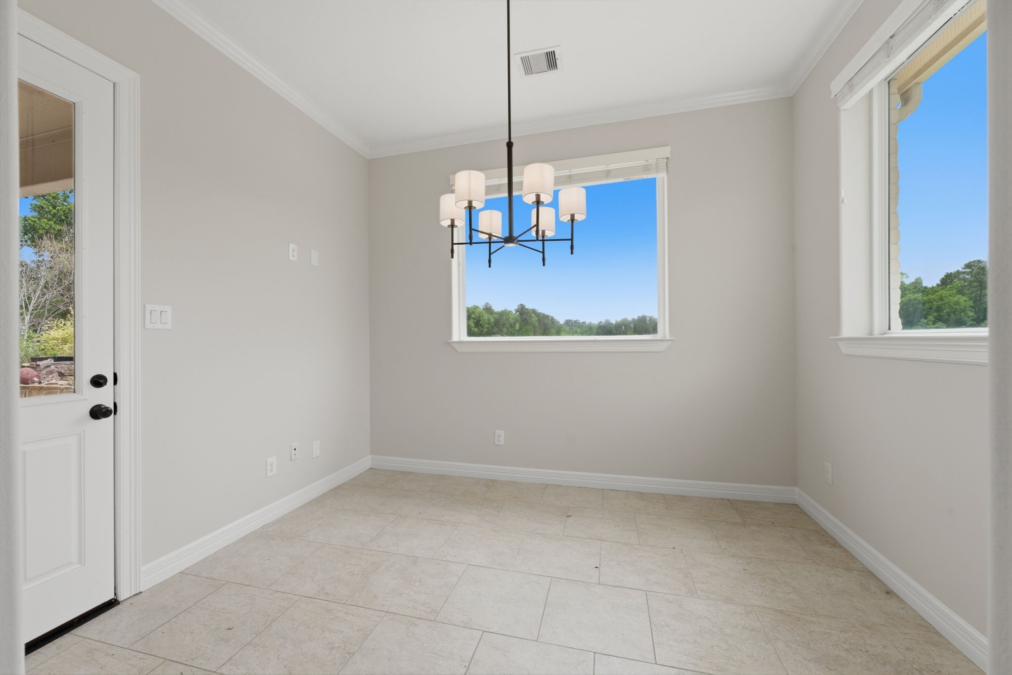 8403 Greenridge Manor Lane Spring, TX 77389 - Photo 17 of 48 Bright breakfast area with neutral walls, a modern chandelier, and patio access.