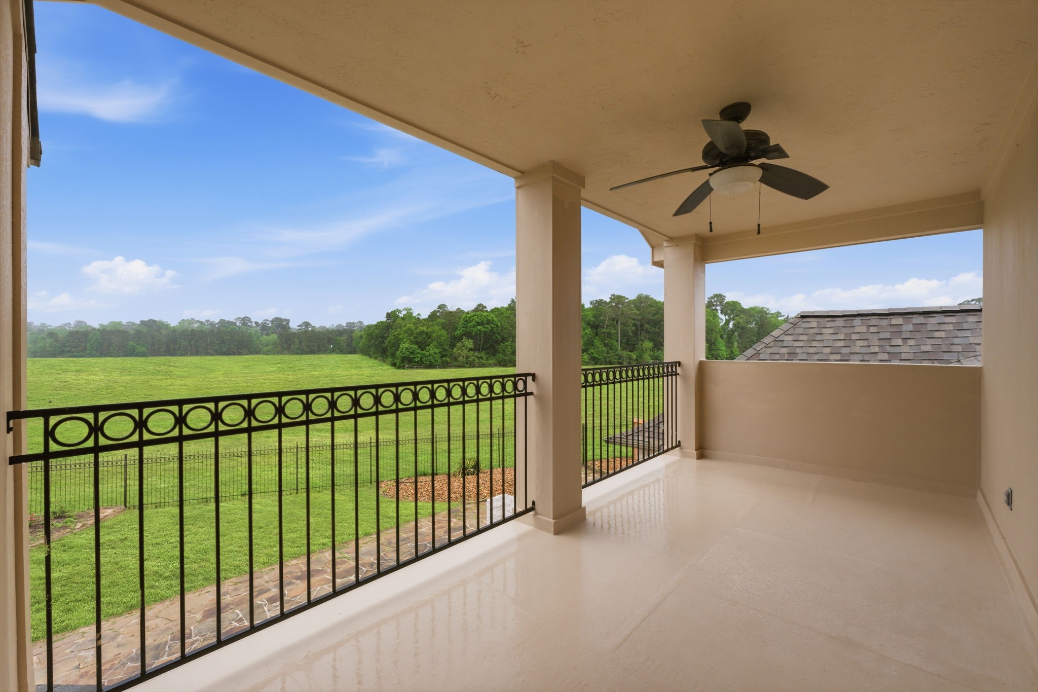 8403 Greenridge Manor Lane Spring, TX 77389 - Photo 36 of 44 A spacious covered balcony overlooks a lush green yard and open landscape. Perfect for enjoying serene, outdoor moments.