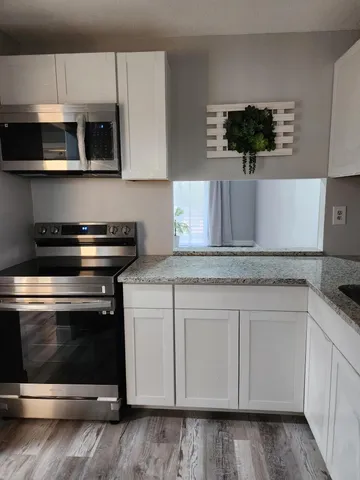 a view of a small space with wooden floor and a window