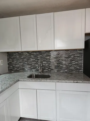 a kitchen with stainless steel appliances granite countertop a stove a microwave and wooden cabinets