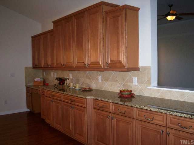 204 Forbes Road Wake Forest, NC 27587 - Photo 5 of 12 The Grand Morning Room expands the open kitchen with fabulous maple cabinets, granite countertops and tiled backsplash.