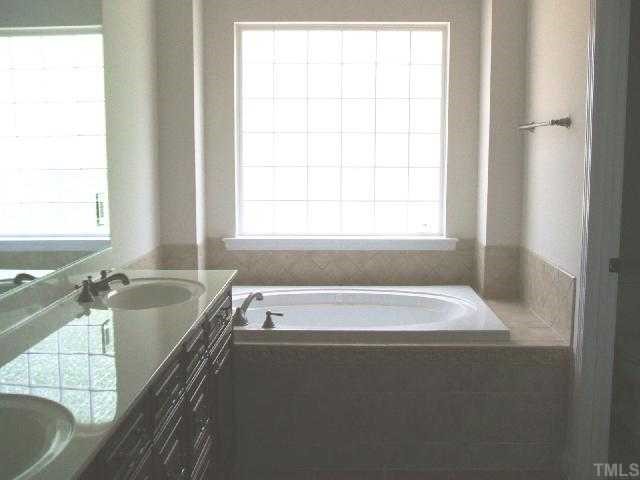 204 Forbes Road Wake Forest, NC 27587 - Photo 9 of 12 Elegant master bath with double vanity, jetted tub with tile surround, shower w/glass door and tile walls, enclosed water closet and acrylic block window for privacy.