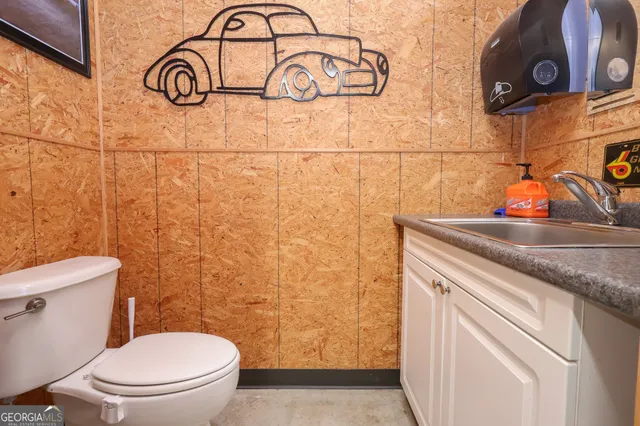 a bathroom with a granite countertop toilet sink and mirror