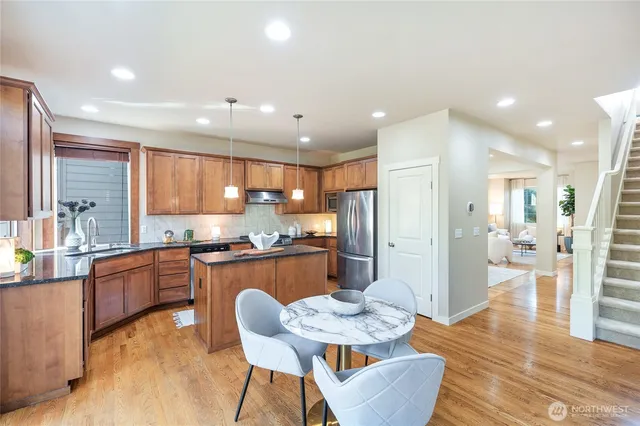 a large kitchen with stainless steel appliances kitchen island granite countertop a large island in the center