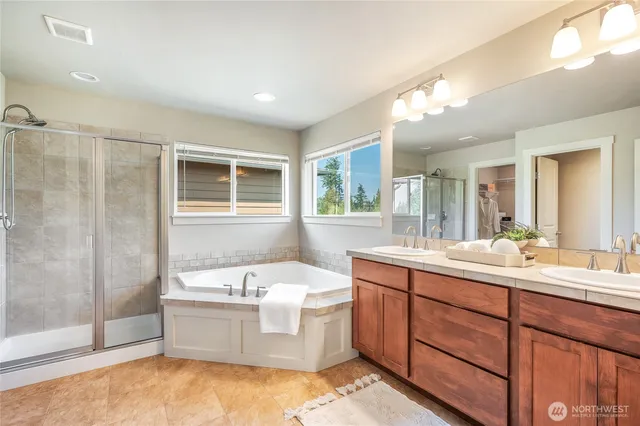 a bathroom with a double vanity sink mirror and bathtub