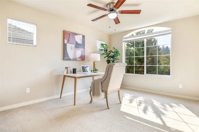 a view of a workspace with furniture and a window